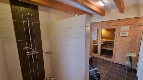 a bathroom with a shower with a glass door at Ferienhaus Sommerwind in Neßmersiel