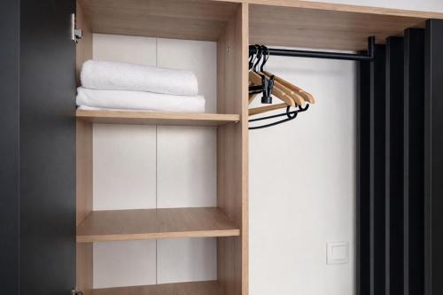 a closet with wooden shelves and towels at NEST by Tendo Stay - Comfort Housing in Falkensee