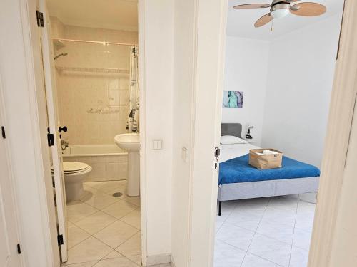 a bedroom with a bed and a bathroom with a toilet at Blife Martya apartment in Olhão