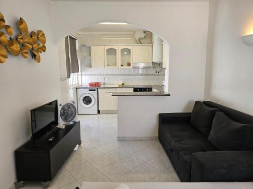 a living room with a couch and a kitchen at Blife Martya apartment in Olhão