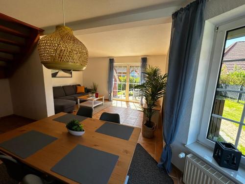 a living room with a dining room table and a living room at Ferienhaus Seenelke in Neßmersiel