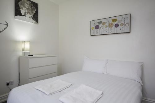 a bedroom with a white bed with two towels on it at Hayy Studios Blackhouse in Huddersfield