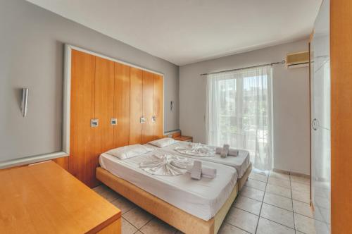 a bedroom with a large bed and a television at Mojo Hotel Laganas Zante in Laganas