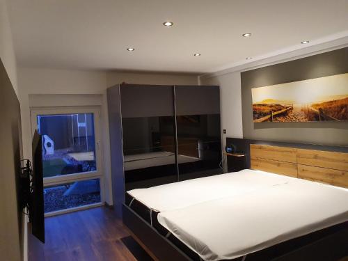 a bedroom with a large bed and a large window at Ferienhaus Wiesenpieper in Dornum
