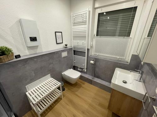 a bathroom with a toilet and a sink at Ferienhaus Margarete in Dornumersiel