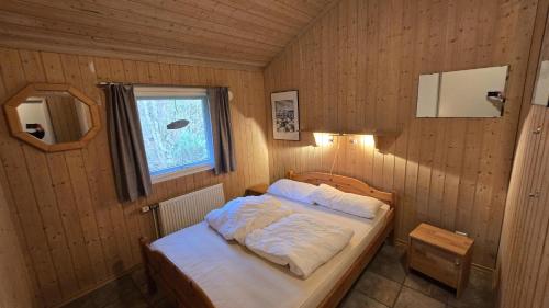 a bedroom with a bed in a wooden room at Ferienhaus Eichhörnchenhöhle in Haren
