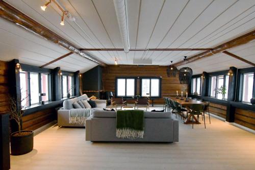 a living room with couches and a table and chairs at Grönländaren Lodge in Funäsdalen