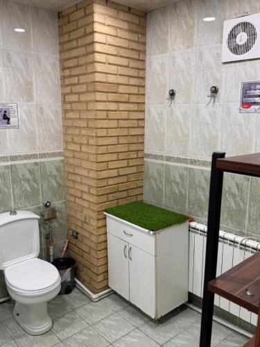 a bathroom with a toilet and a green counter at LevelUp ApartHotel in Baku