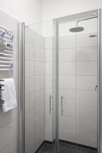 a shower with a glass door in a bathroom at NEST by Tendo Stay - Comfort Housing in Falkensee