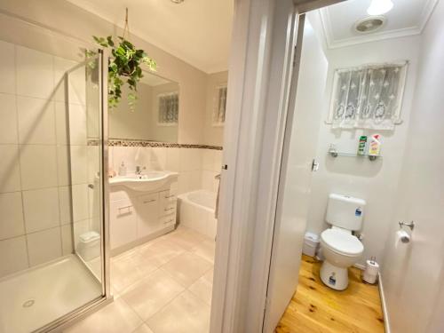 a bathroom with a shower and a toilet and a sink at Private 3Bed Home with Large Deck Central Location in Eaglehawk