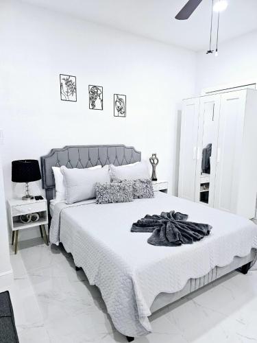 a white bedroom with a large bed with white walls at Romantic Suite in Tampa