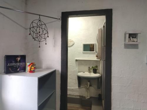 a white bathroom with a sink and a mirror at Cocos Island in Bettyʼs Bay