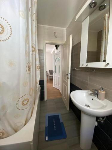 a bathroom with a sink and a tub and a toilet at Apartments Luna in Bar