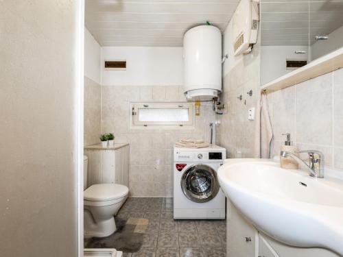 a bathroom with a toilet and a sink and a washing machine at Chalupa Sibřinka in Korkusova Huť