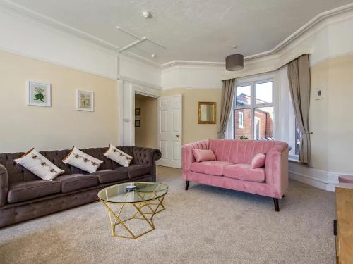 a living room with two couches and a pink chair at Spacious Buxton house with hot tub and pool table in Norwich