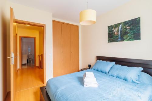 a bedroom with a blue bed with towels on it at Santana Lens & Trail House in Santana