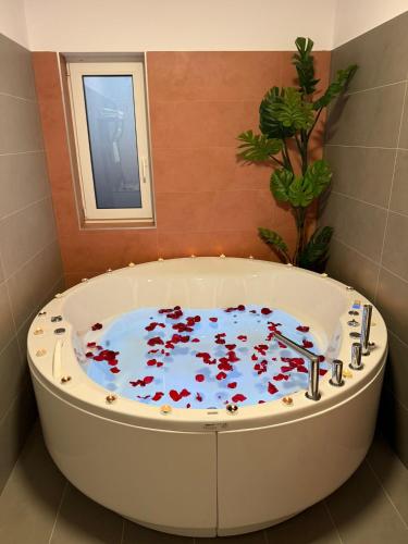 a bath tub filled with red flowers in a bathroom at VISAJ Jacuzzi Romantic in Timişoara