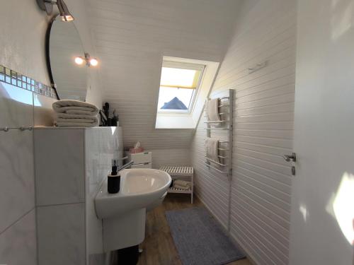a bathroom with a sink and a toilet and a window at Gästehaus Schuppe in Tarp in Tarp