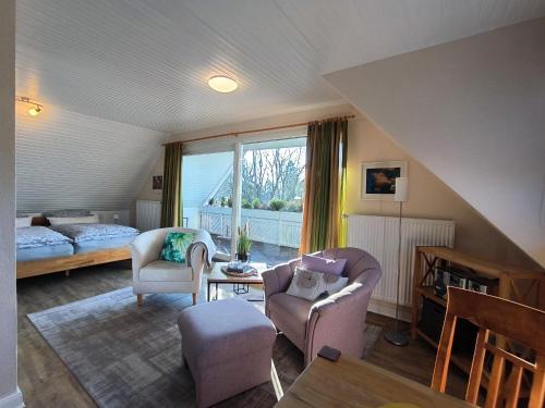 a living room with two chairs and a bed at Gästehaus Schuppe in Tarp in Tarp