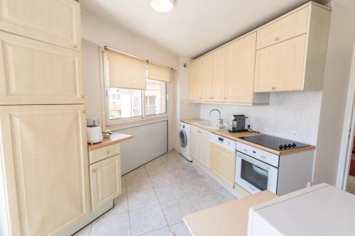 a kitchen with white cabinets and a stove top oven at Cannes Croisette Prestige Apart'hotel in Cannes