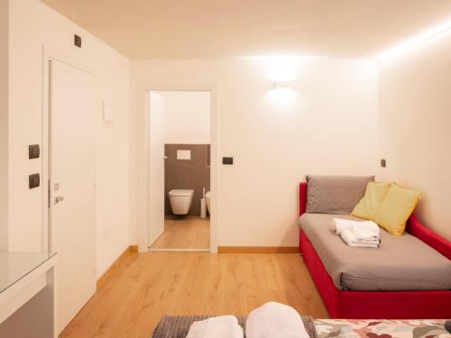 a living room with a couch and a bathroom at Foresteria Dambro rooms -2 Min walk to Bernina Express in Tirano