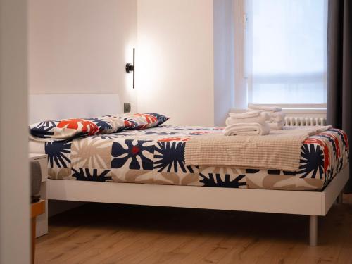 a bedroom with a bed with a comforter on it at Foresteria Dambro rooms -2 Min walk to Bernina Express in Tirano