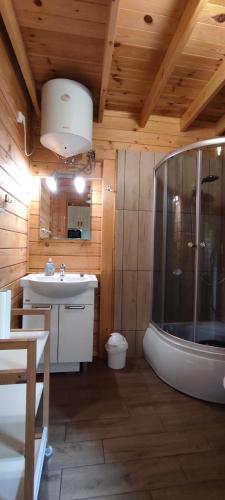a bathroom with a shower and a sink at Domki Bursztynowa Zatoka 2 in Sarbinowo