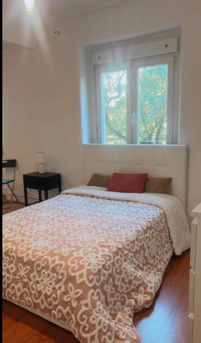 a bedroom with a large bed with a window at Quarto em apartamento in Odivelas