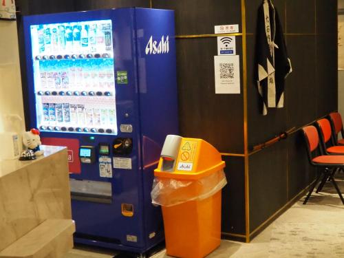 a drink machine with a trash can next to it at Phoenix Inn in Tokyo