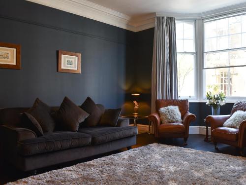 a living room with a couch and two chairs at Scarborough Esplanade in Scarborough