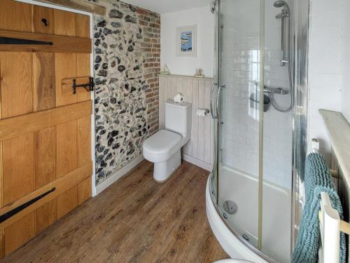 a bathroom with a toilet and a glass shower at The Cottage in Broadstairs