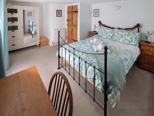 a bedroom with a bed and a wooden table at The Cottage in Broadstairs