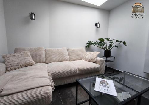 a living room with a couch and a glass table at L'Atelier de Claude in Wattwiller