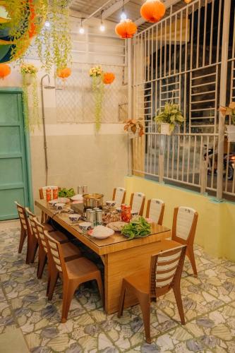 a dining room table with chairs and a long table at Thiện Homestay Dốc Lết -Gần Biển & Nguyên Căn in Ba Ha