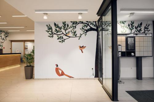 a hallway with a wall with birds on it at Hotel Park Superior 3* in Čakovec
