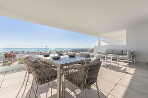 a table and chairs on a balcony with a view of the ocean at Doña Julia Sea Utopia in Casares