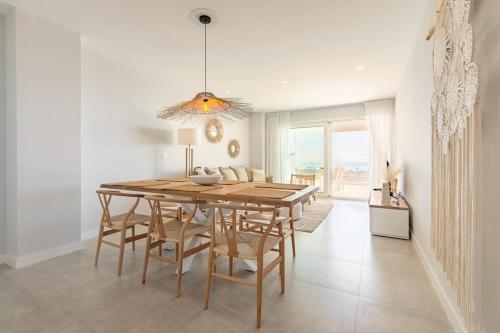a dining room with a wooden table and chairs at Doña Julia Sea Utopia in Casares