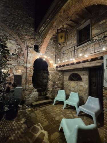 a room with two white chairs and a stone fireplace at Vacation Home Tuscany Pisa-Lucca 2 in Filettole