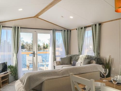 a living room with a couch and a view of the water at Waterfoot Lodge W09 in Amotherby