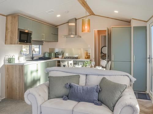a living room with a couch and a kitchen at Waterfoot Lodge W09 in Amotherby