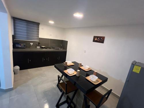 a dining room with a black table and chairs at Casa cerca del aeropuerto con dos habitaciones todo incluido in Monterrey