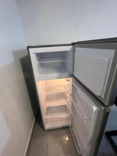 an empty refrigerator with its door open in a room at Casa cerca del aeropuerto con dos habitaciones todo incluido in Monterrey