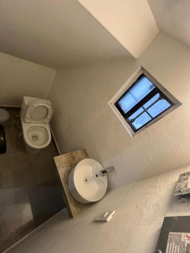 a small bathroom with a toilet and a window at Casa cerca del aeropuerto con dos habitaciones todo incluido in Monterrey