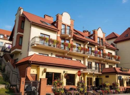 a large building with balconies and flowers on it at Apartamenty Smętek in Ełk