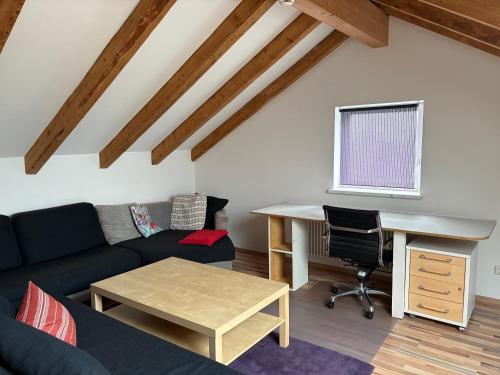 a living room with a couch and a desk at Delfinia in Althegnenberg