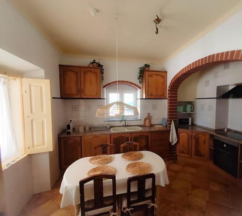 a kitchen with a table with chairs in it at Markádia in Alvito