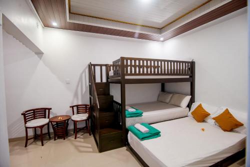 a room with two bunk beds and a table and chairs at Eric Dolphin Villa in Lovina