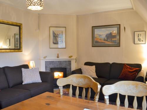 a living room with a couch and a fireplace at Hawthorn in Llanddona