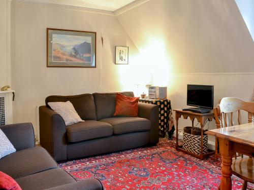 a living room with a couch and a television at Hawthorn in Llanddona