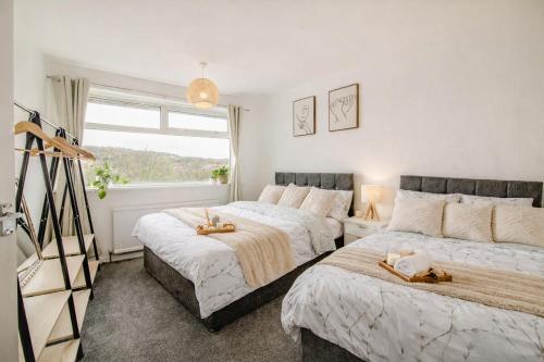 a bedroom with two beds and a window at Serene Boho Retreat: White Oak Charm House 10ppl in Sheffield